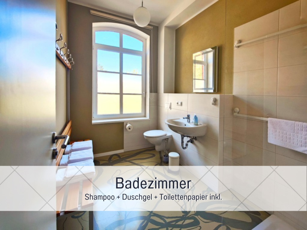 Modernes Badezimmer mit bodentiefer Dusche, Waschbecken und großem Fenster mit Tageslicht.
