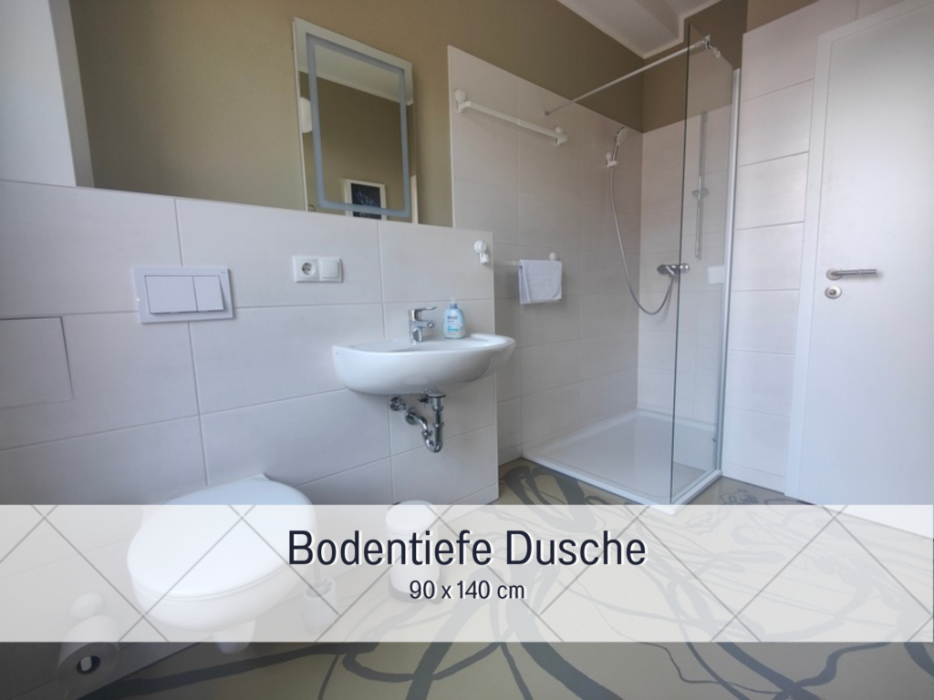 Helles Badezimmer mit großer, ebenerdiger Dusche und weißen Fliesen.